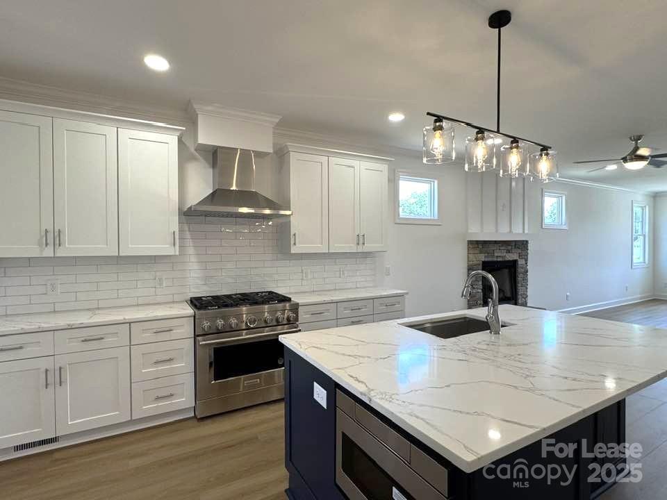 8070 Blackwood Road Denver, NC 28037 - Photo 2 of 39 a kitchen with granite countertop a stove a kitchen island a sink cabinets and wooden floor
