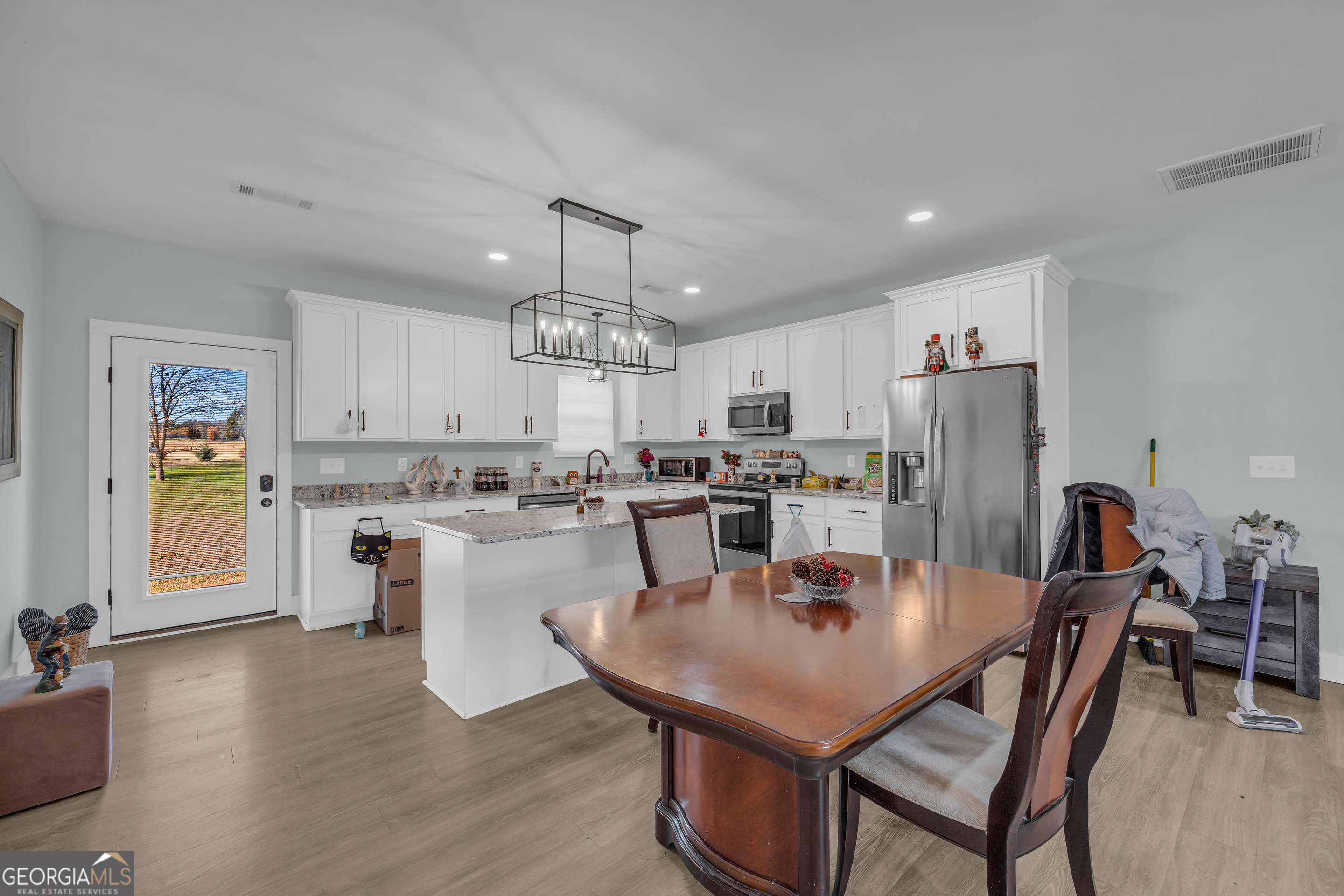 1279 South Fairview Road Lavonia, GA 30553 - Photo 22 of 43 a kitchen with a dining table chairs refrigerator and cabinets