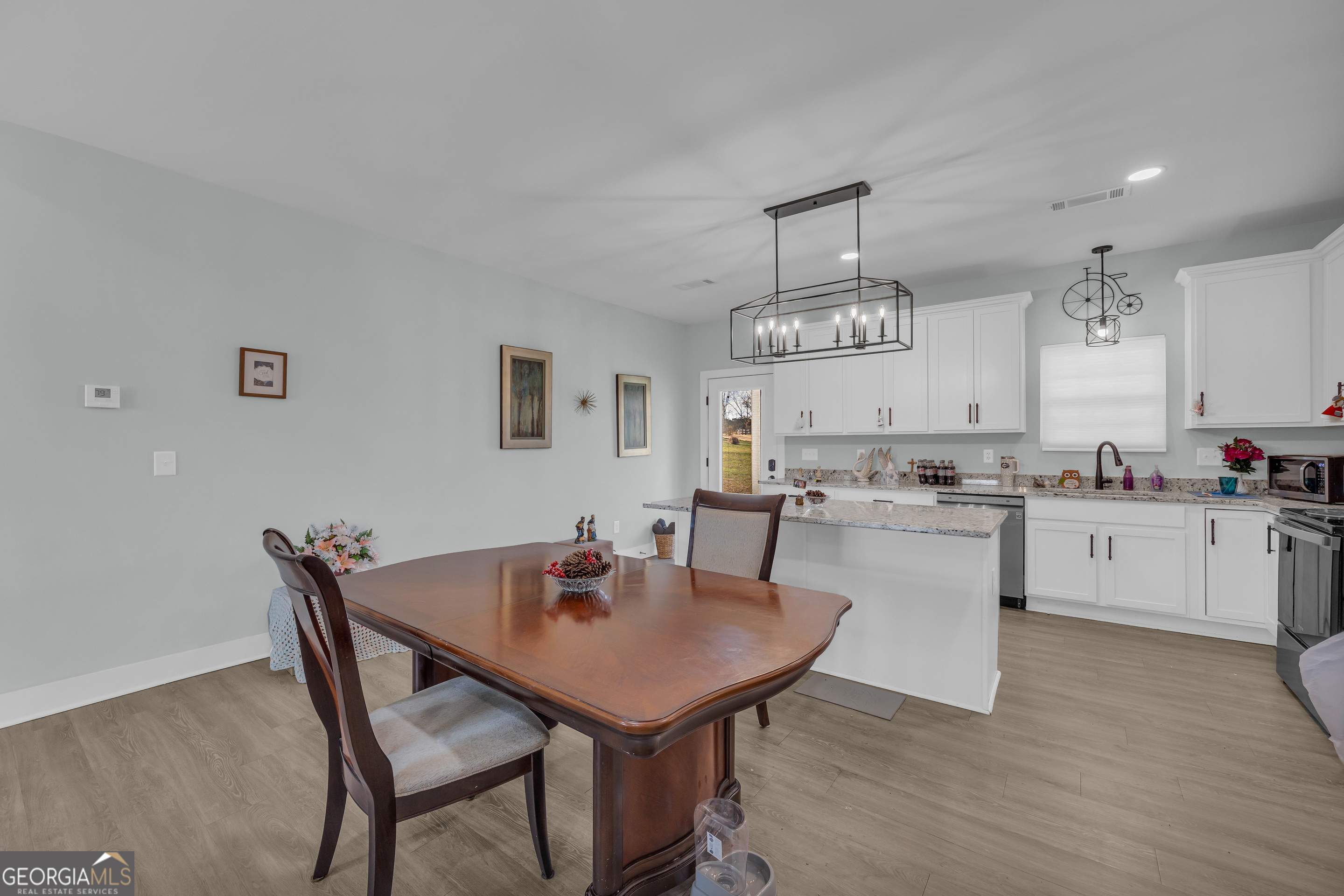 1279 South Fairview Road Lavonia, GA 30553 - Photo 23 of 43 a kitchen with a dining table chairs stove and cabinets