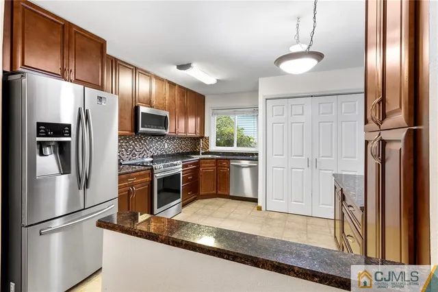 a kitchen with stainless steel appliances granite countertop a refrigerator a stove a sink and a refrigerator