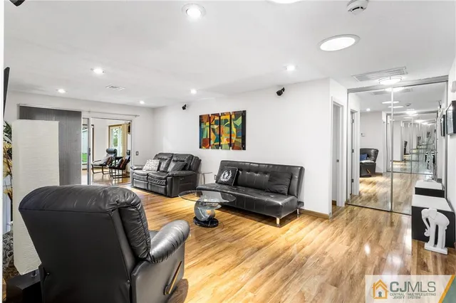 a living room with furniture kitchen view and a wooden floor