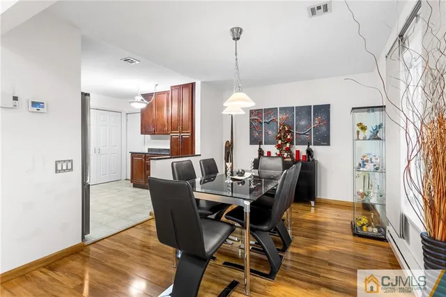 a view of a dining room with furniture a chandelier and wooden floor