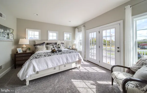 a spacious bedroom with a bed and glass window