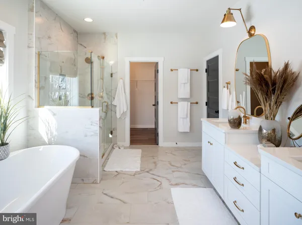 a spacious bathroom with a double vanity sink a mirror a bathtub and shower