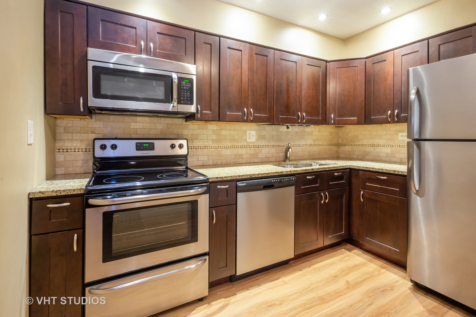 2323 South Goebbert Road, Unit 207 Arlington Heights, IL 60005 - Photo 5 of 12 a kitchen with granite countertop wooden cabinets and stainless steel appliances