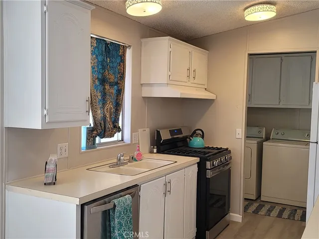 a kitchen with a sink a stove and cabinets