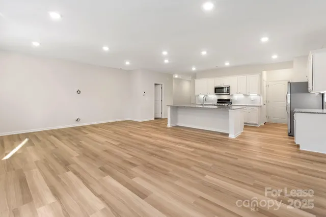 a view of kitchen view wooden floor stainless steel appliances and cabinets