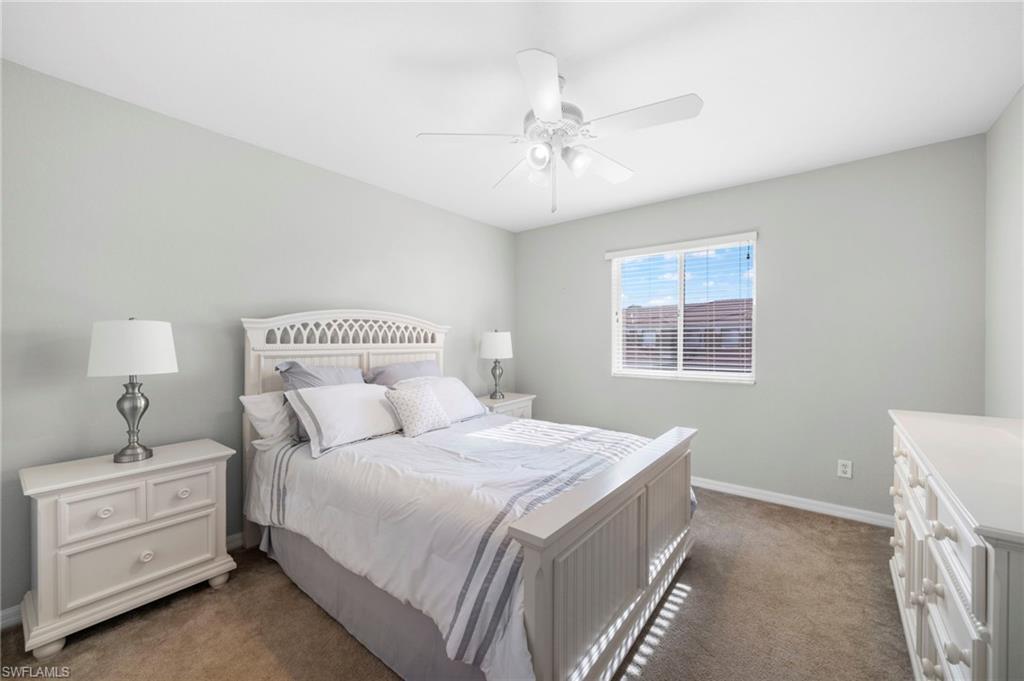 17567 Brickstone Loop Fort Myers, FL 33967 - Photo 16 of 27 a bedroom with a bed and a chandelier