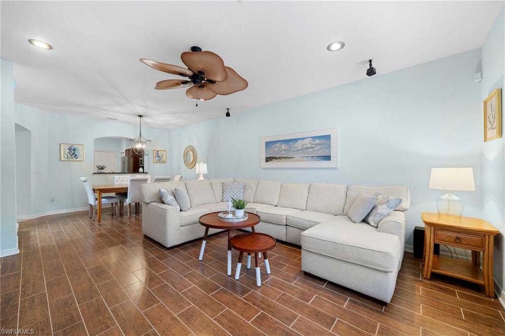 17567 Brickstone Loop Fort Myers, FL 33967 - Photo 2 of 27 a living room with couches a fireplace and a dining table with wooden floor