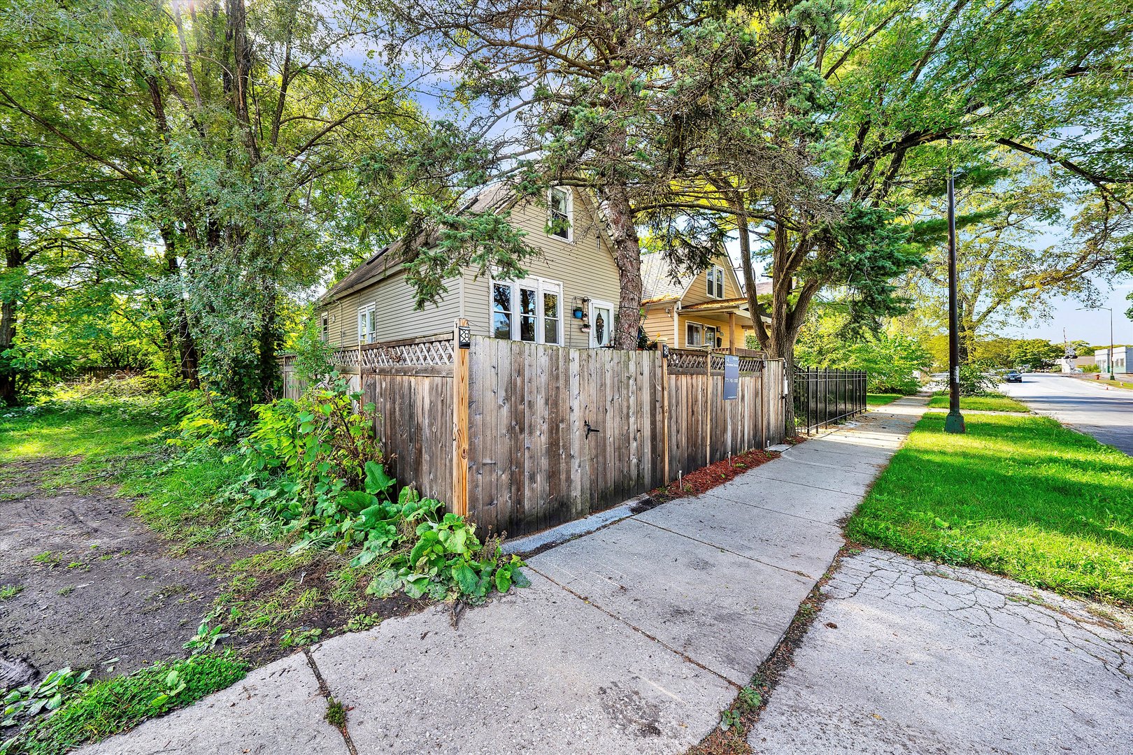 331 West 107th Street Chicago, IL 60628 - Photo 22 of 28 a view of a backyard with large trees and wooden fence