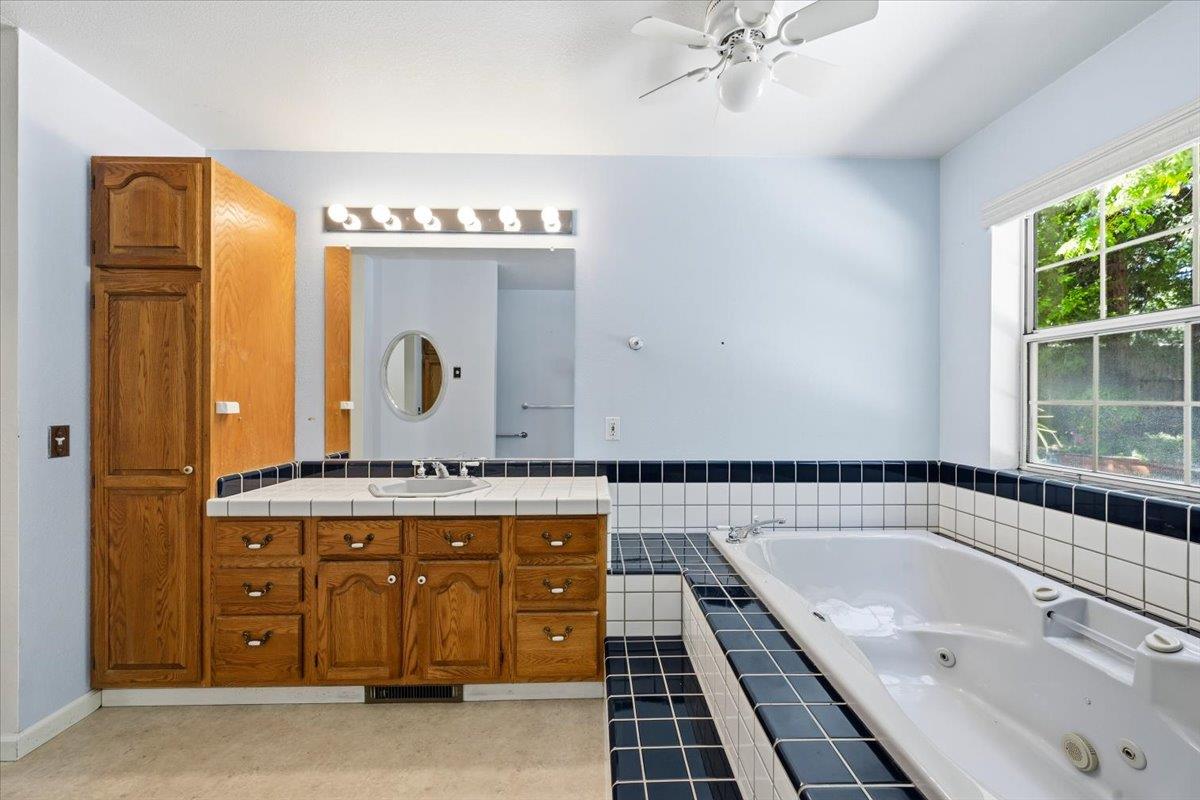 12600 Friar Tuck Road Grass Valley, CA 95949 - Photo 20 of 56 a bathroom with a granite countertop sink mirror vanity and bathtub