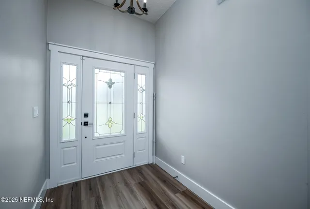a view of a room with wooden floor and a window