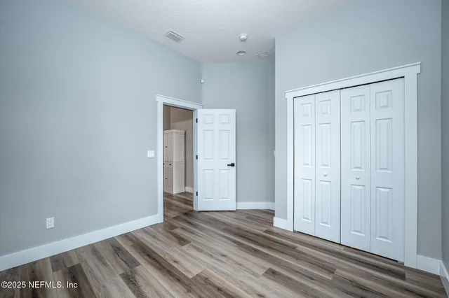 a view of a closet area with wooden floor