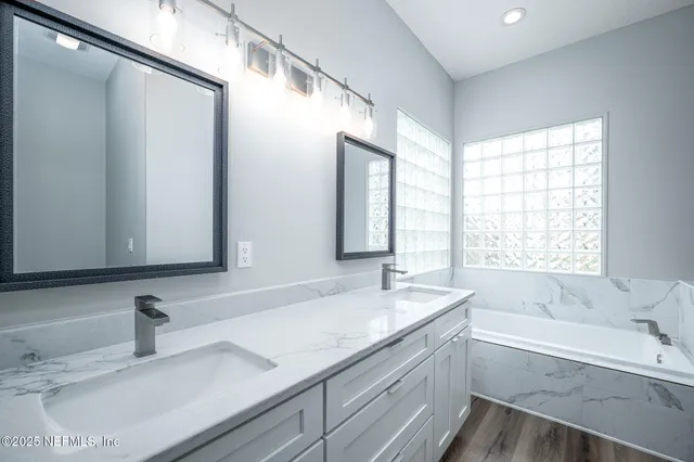 a bathroom with a tub sink and mirror