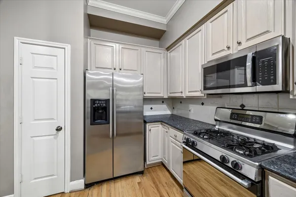 a kitchen with stainless steel appliances granite countertop a stove a refrigerator and cabinets