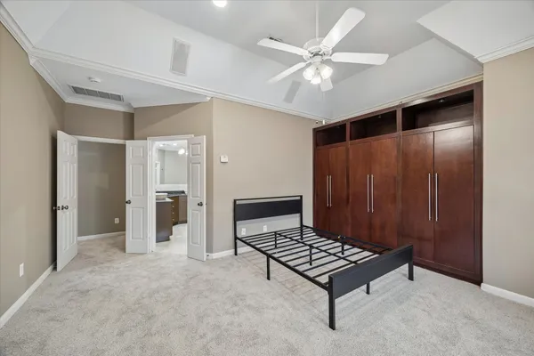 a living room with a baby crib and a ceiling fan