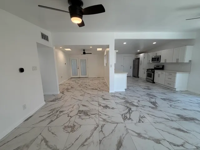 a large kitchen with stainless steel appliances kitchen island granite countertop a sink and cabinets