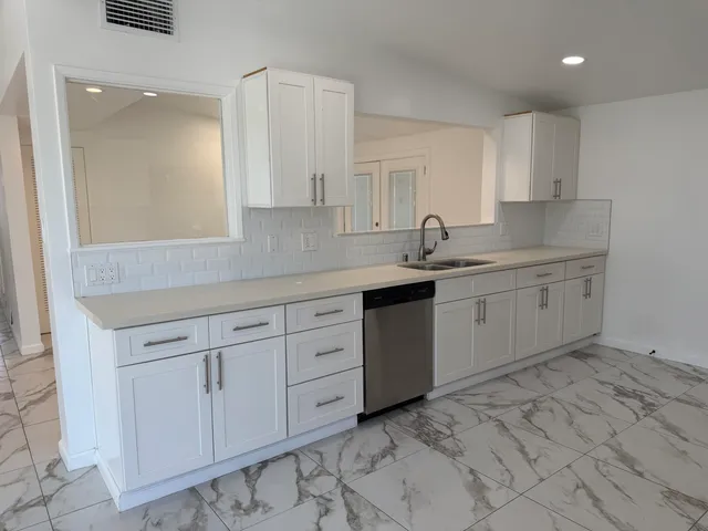 a kitchen with white cabinets and stainless steel appliances