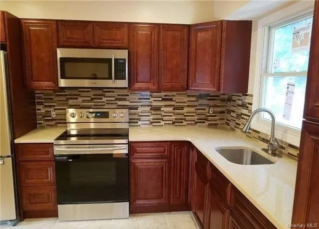 a kitchen with granite countertop a sink and a stove top oven