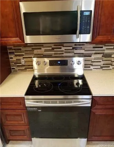 a stove top oven sitting inside of a kitchen