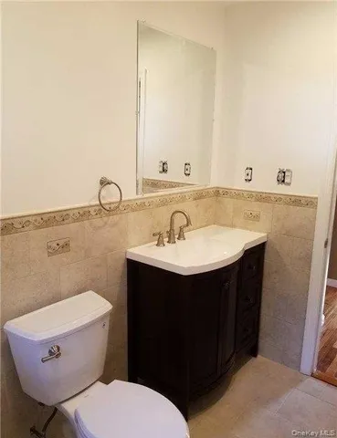 a bathroom with a sink a toilet and mirror