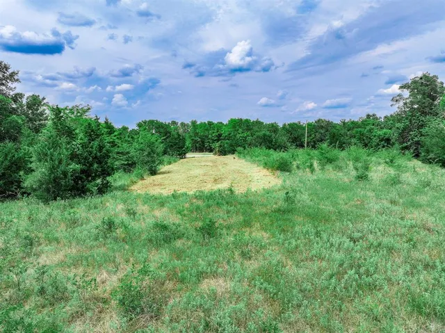 an aerial view of residential house with outdoor space and trees all around