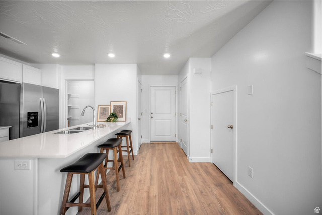 2216 Wolverine Way Washington, UT 84780 - Photo 7 of 29 Open-concept kitchen featuring a spacious peninsula with seating, stainless steel appliances, a built-in pantry, and wood-finish flooring