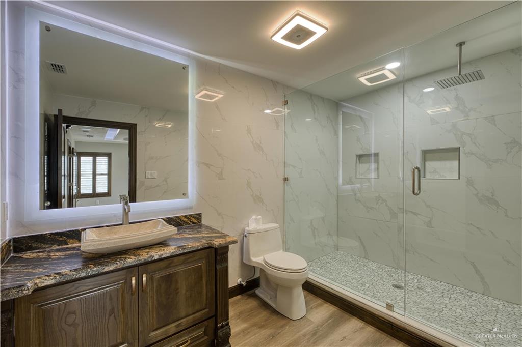 2916 Fletcher Street Weslaco, TX 78599 - Photo 41 of 45 a bathroom with a granite countertop sink a toilet and shower