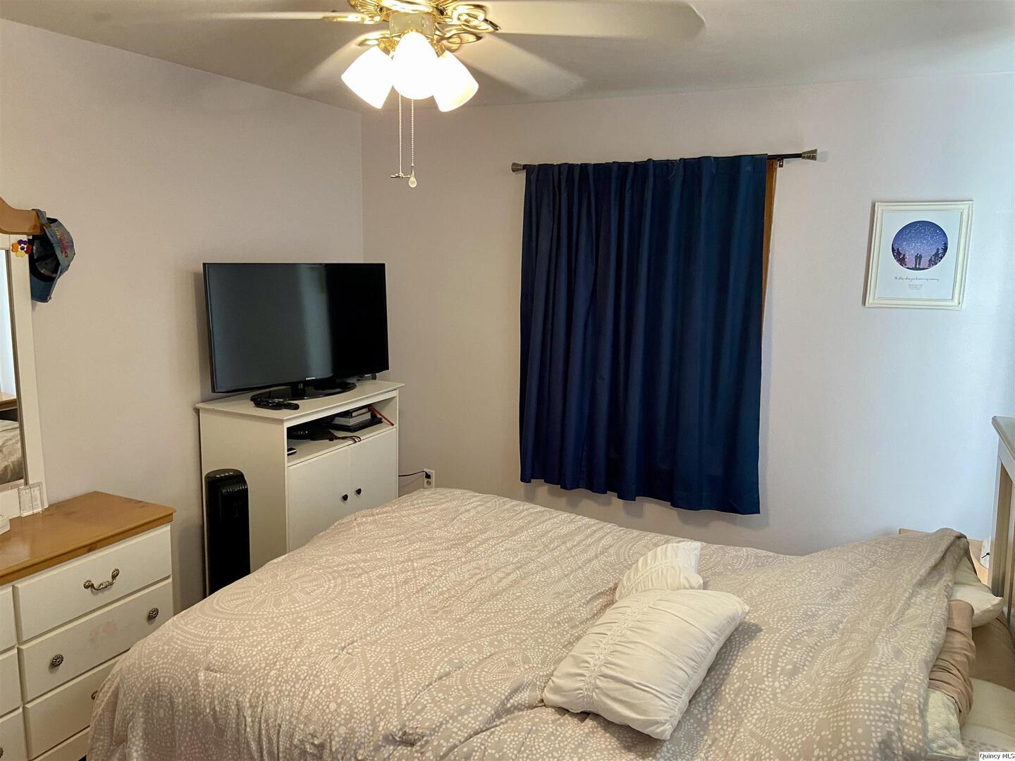 1632 North 24th Street Quincy, IL 62301 - Photo 14 of 36 a bedroom with a bed and a flat tv screen on dresser