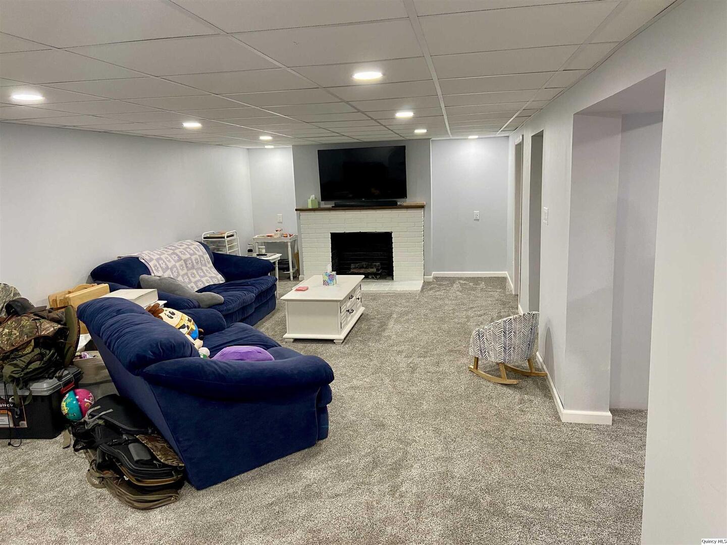 1632 North 24th Street Quincy, IL 62301 - Photo 23 of 36 a living room with furniture a fireplace and a flat screen tv