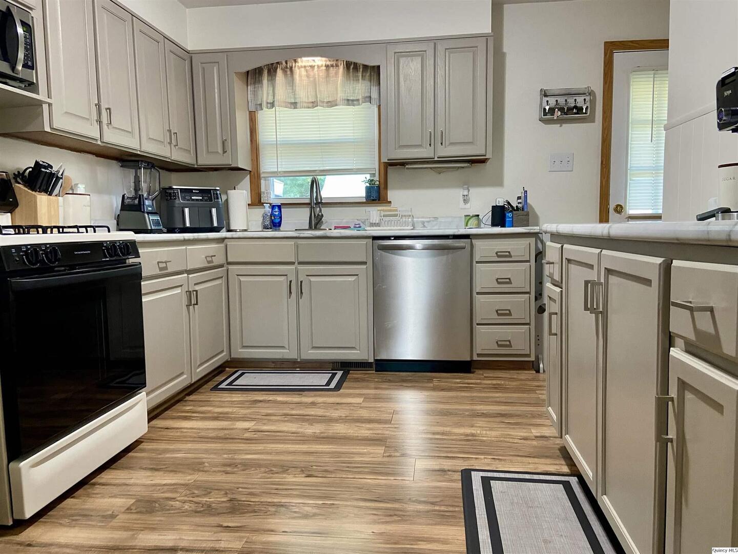 1632 North 24th Street Quincy, IL 62301 - Photo 4 of 36 a kitchen with white cabinets and white appliances
