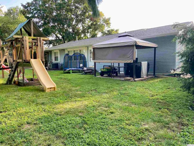 a view of a house with a yard and sitting area