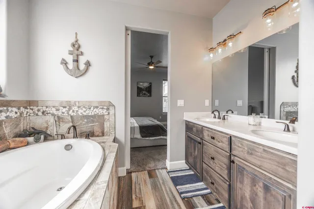 a bathroom with a tub sink and mirror