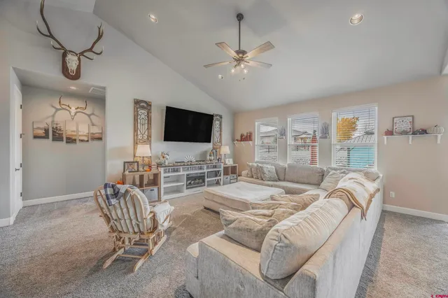 a living room with furniture a flat screen tv and a large window