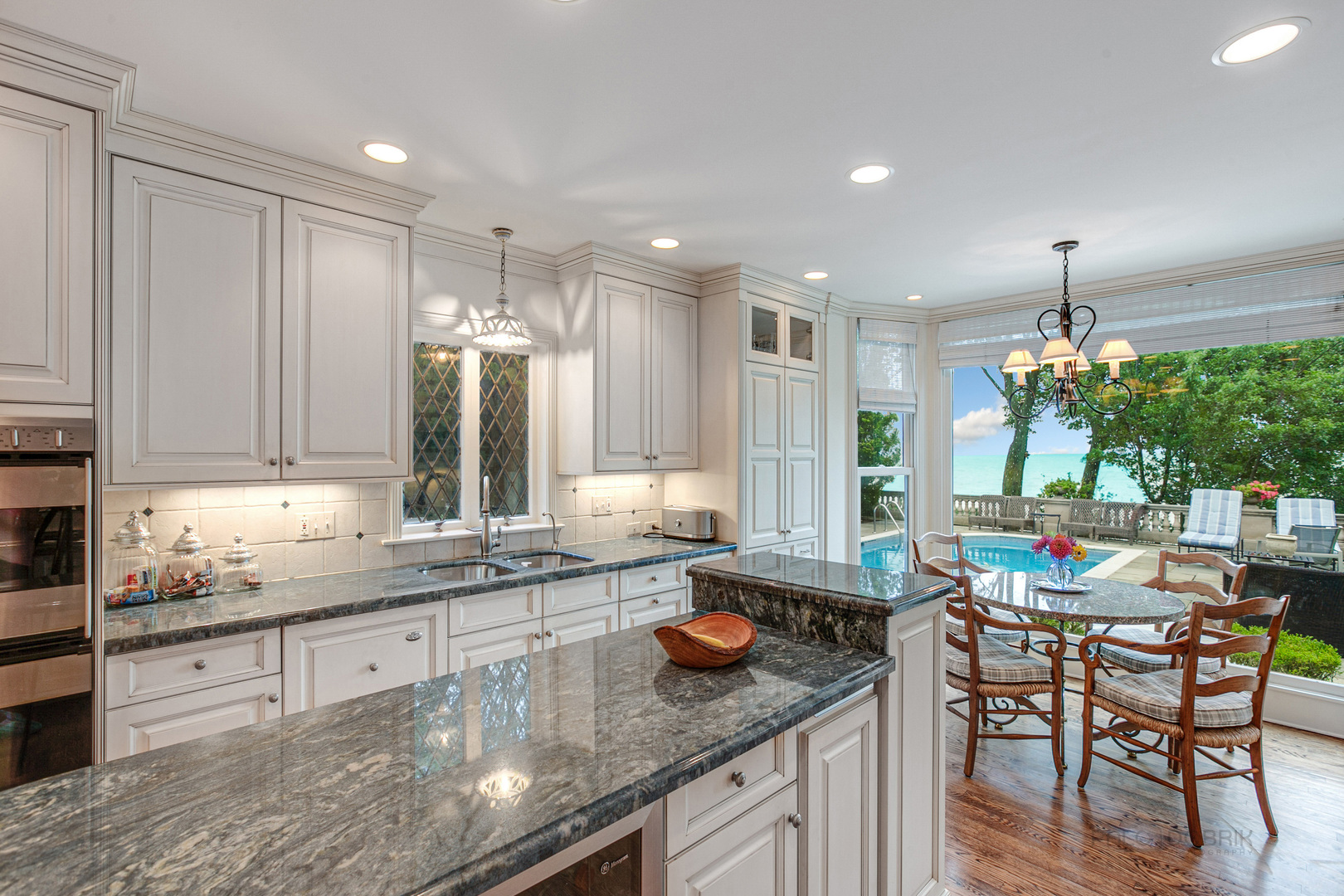 473 Sheridan Road Winnetka, IL 60093 - Photo 12 of 32 a kitchen with granite countertop lots of white cabinets stainless steel appliances dining table and chairs