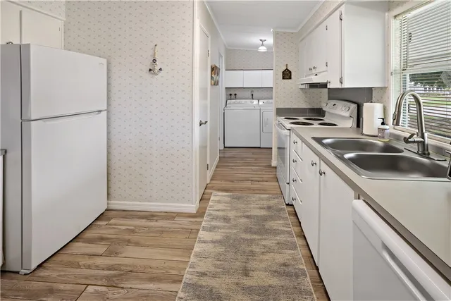 a kitchen with kitchen island a sink a refrigerator a stove and cabinets