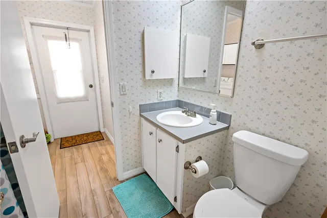 a bathroom with a granite countertop toilet sink and mirror