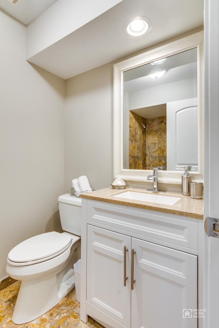 131 Chestnut Road Northbrook, IL 60062 - Photo 10 of 26 a bathroom with a toilet a sink and mirror