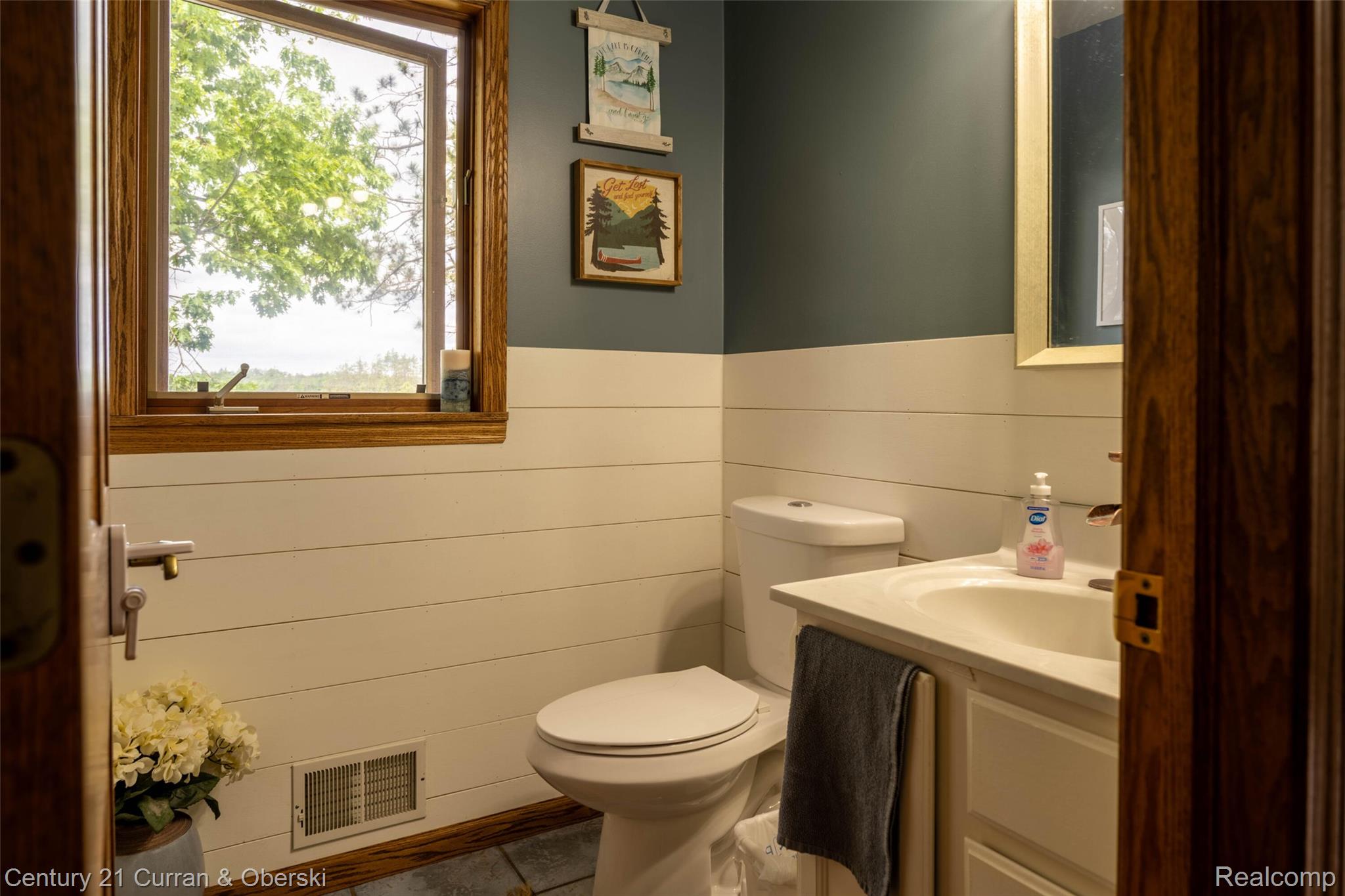 8775 Winding Rdg Drive Millersburg, MI 49759 - Photo 21 of 53 Bathroom featuring a wood-framed window, shiplap wall paneling, and a single vanity with an integrated sink