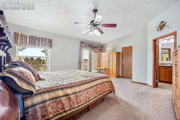 a bedroom with a large bed a chandelier and dresser