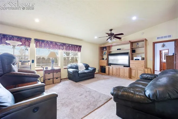 a living room with furniture fireplace and large windows