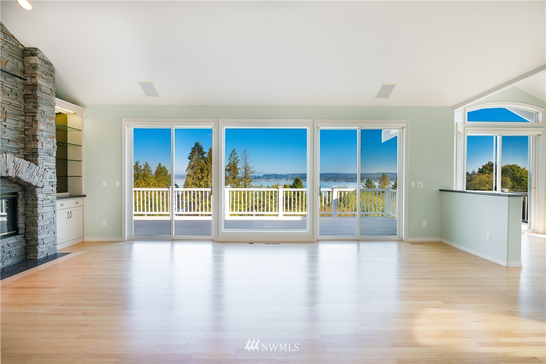a view of empty room with wooden floor and fireplace