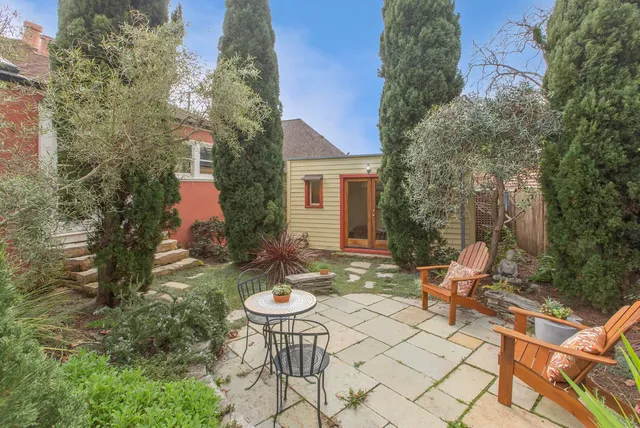 a view of a house with backyard sitting area and garden