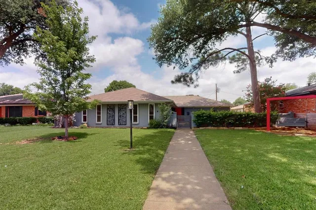 a front view of a house with a yard and trees