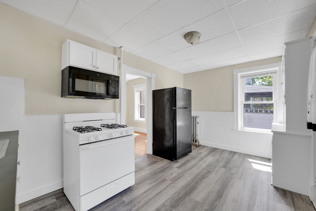242 Fort Pleasant Avenue Springfield, MA 01108 - Photo 7 of 42 a kitchen with a refrigerator stove and wooden floor