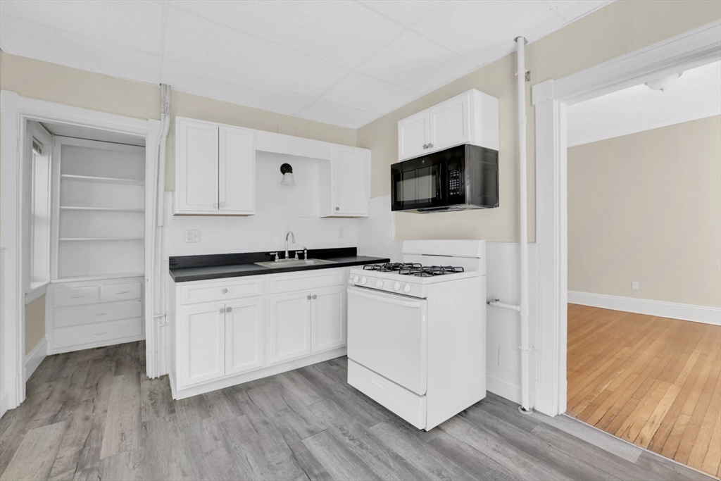 242 Fort Pleasant Avenue Springfield, MA 01108 - Photo 8 of 42 a kitchen with a refrigerator and white cabinets