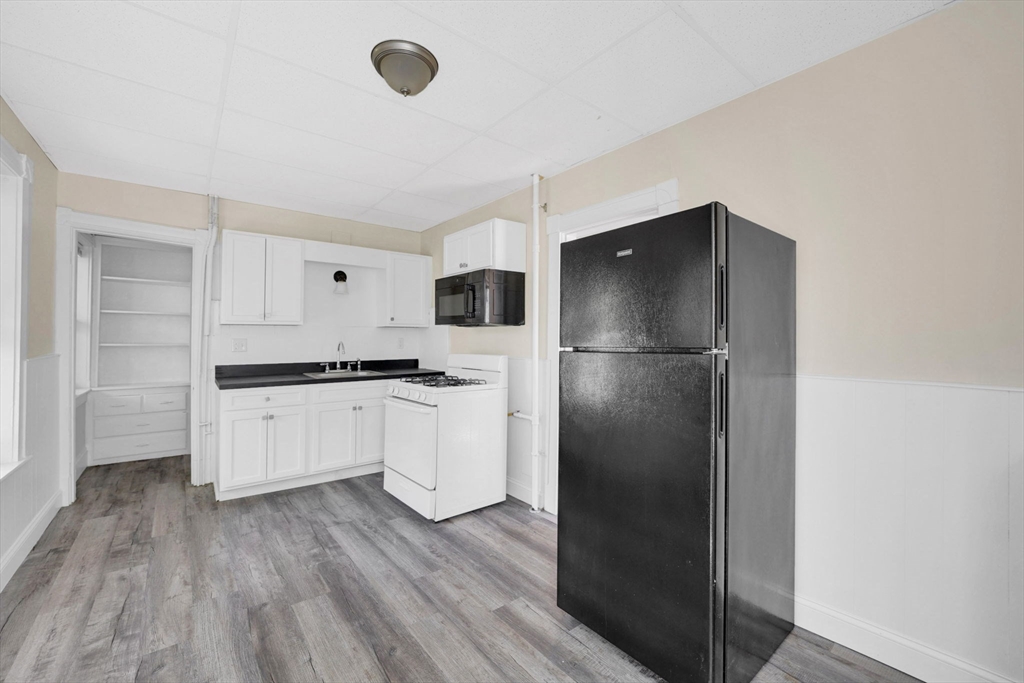 242 Fort Pleasant Avenue Springfield, MA 01108 - Photo 9 of 42 a kitchen with a refrigerator and white cabinets