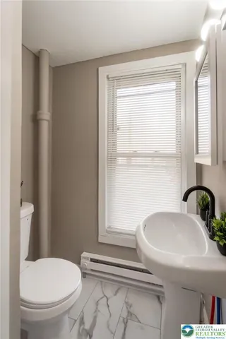 a bathroom with a toilet a sink and a window