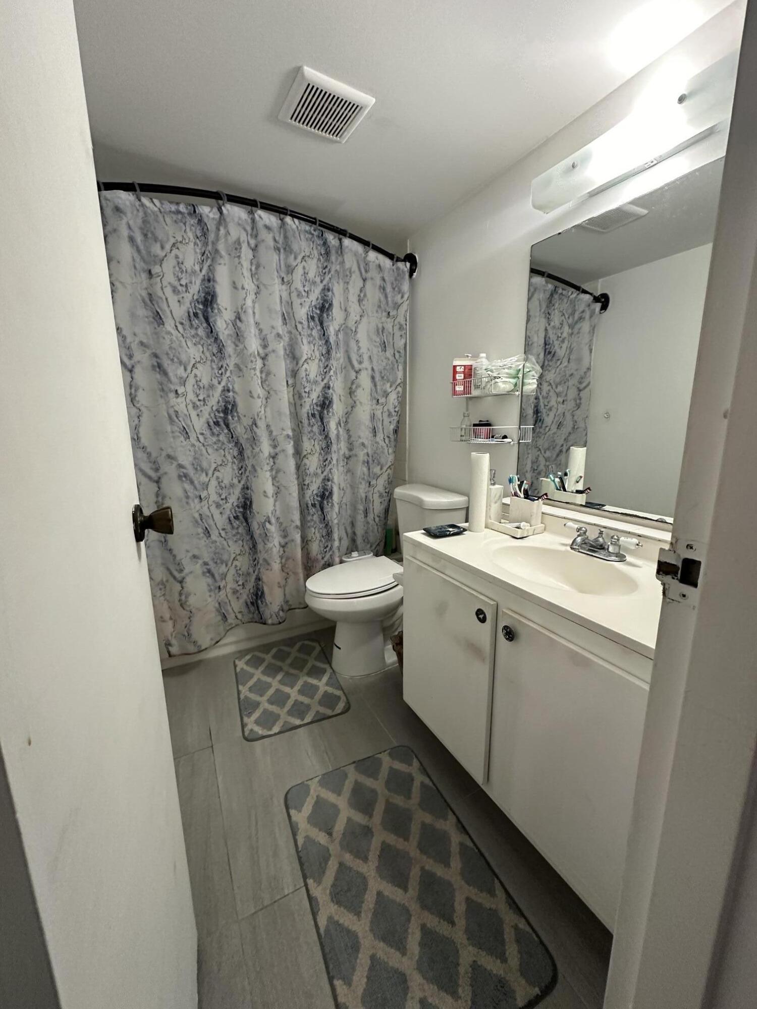 8341 Sands Point Boulevard, Unit B206 Tamarac, FL 33321 - Photo 11 of 11 a bathroom with a sink and a mirror