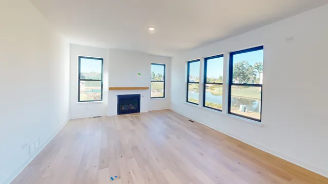 an empty room with windows and fireplace